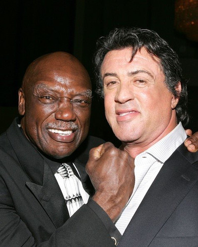 Sylvester Stallone'nin dunya capinda bir yildiz olmasinda onemli katkisi olan efsane 'Rocky' filmindeki antrenoru Tony Burton, 78 yasinda hayatini kaybetti. Kendisi de gercek hayatta profesyonel bir agir siklet boksoru ve Amerikan futbolu oyuncusu olan Burton, alti bolum cekilen Rocky filminde 'Aci yok sampiyon' repligi ile hafizalara kazindi. (Kaynak: Facebook)