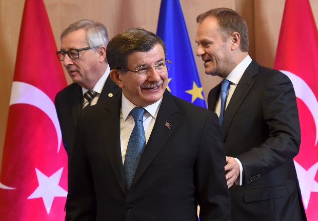 Turkish Prime Minister Davutoglu is welcomed by European Commission President Juncker and European Council President Tusk during an EU-Turkey summit in Brussels