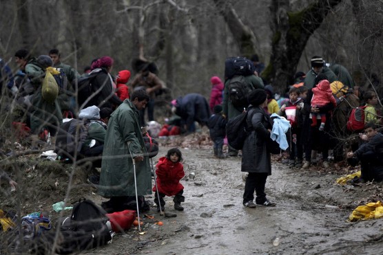 Migrants walk through a forest as they look for a way to cross the Greek-Macedonian border, near the village of Idomeni, Greece, March 14, 2016. REUTERS/Alexandros Avramidis