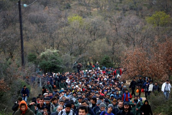 Migrants look for a way to cross the Greek-Macedonian border near the village of Idomeni